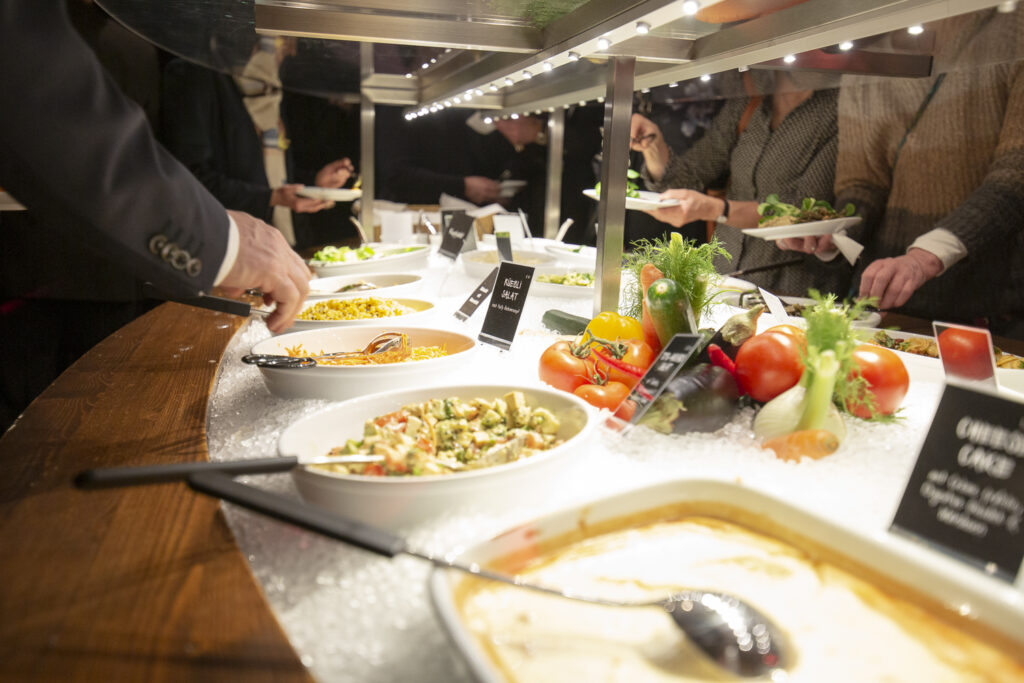 Buffet im tibits in Darmstadt, eingedeckt, Menschen stehen mit Tellern davor und nehmen sich
