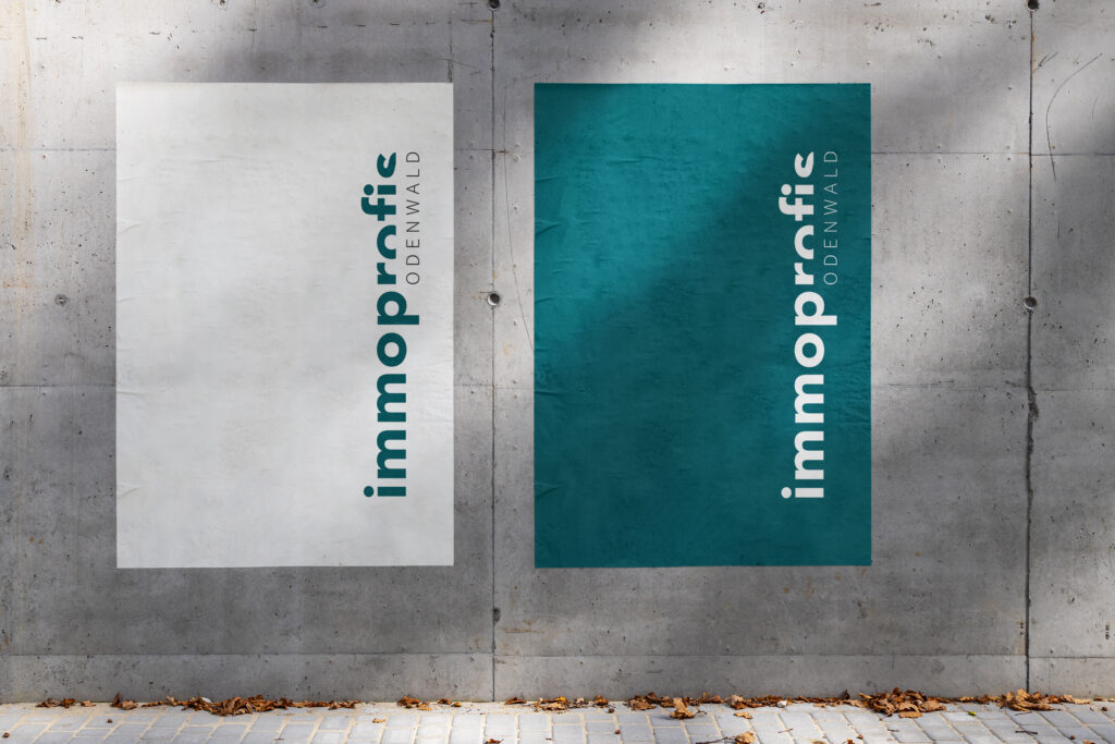 Mockup von zwei schlichten Plakaten von immoprofis Odenwald in weiß und petrol an einer Betonwand