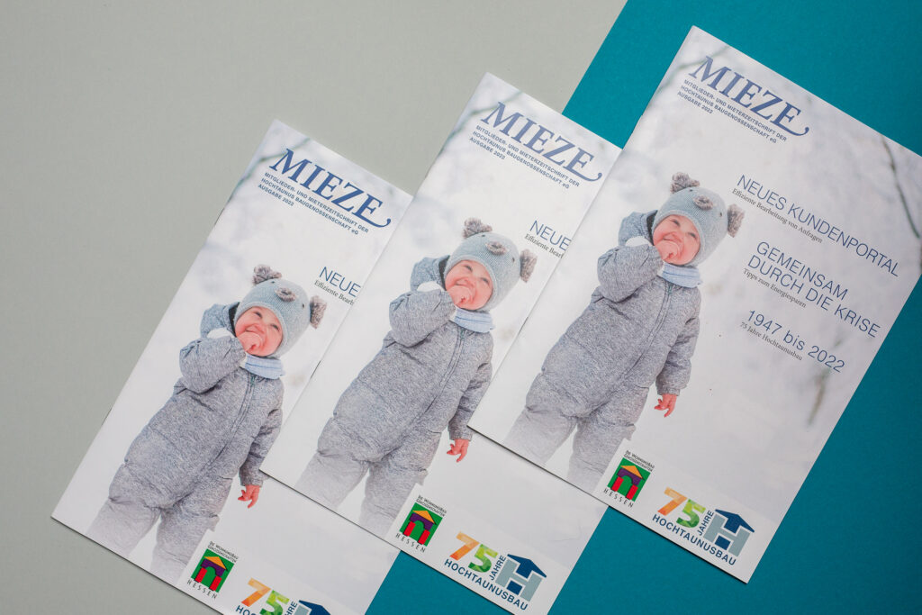 Cover der Zeitschrift ist dreimal auf farbigen (grau und blauen) Kartons platziert